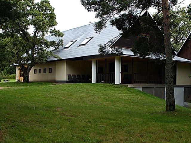 Laugu Guesthouse في Kuusalu: بيت أبيض بسقف مقامر على عشب