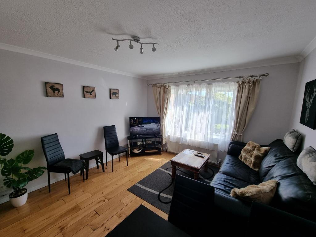 sala de estar con sofá, mesa y sillas en 168 - ExcellentStays - 2 Bedroom Flat en Stanwell