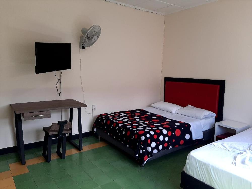 a bedroom with a bed and a desk and a tv at Hotel Majestic in Ocaña