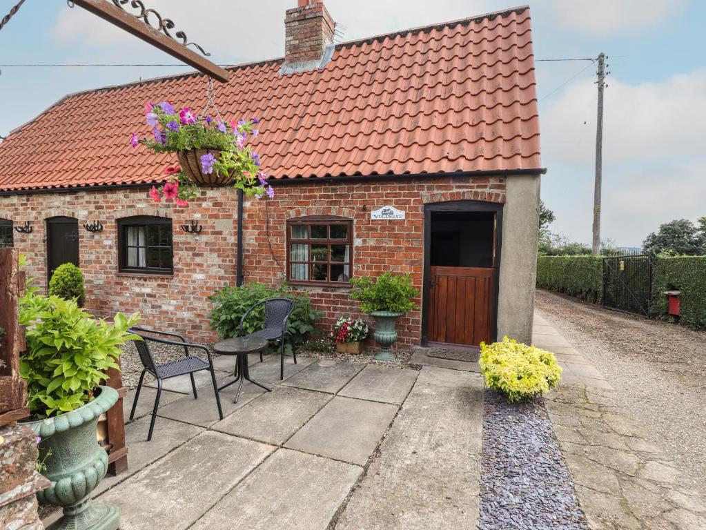 a brick house with a table and chairs at Woldsend Cottage in Horncastle