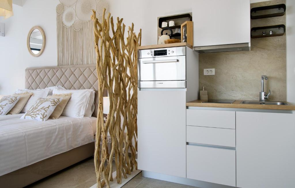 a bedroom with a bed and a white kitchen at Gallery Luxury Suites & Rooms-Only Adults in Split