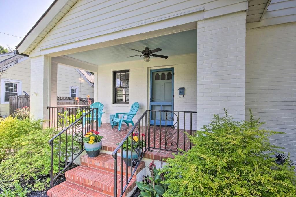 uma casa com um alpendre com 2 cadeiras e uma ventoinha em Historic Augusta Cottage with Mid Century Vibe! em Augusta