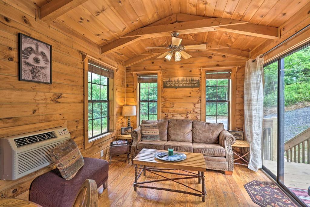 a living room with a couch and a table at Quaint Log Cabin with Views Near West Jefferson in Warrensville