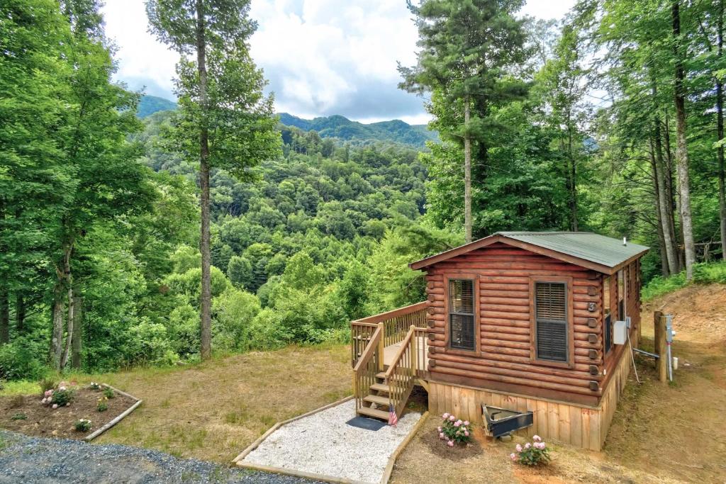 a log cabin in the woods with a staircase at Quaint Log Cabin with Views Near West Jefferson in Warrensville