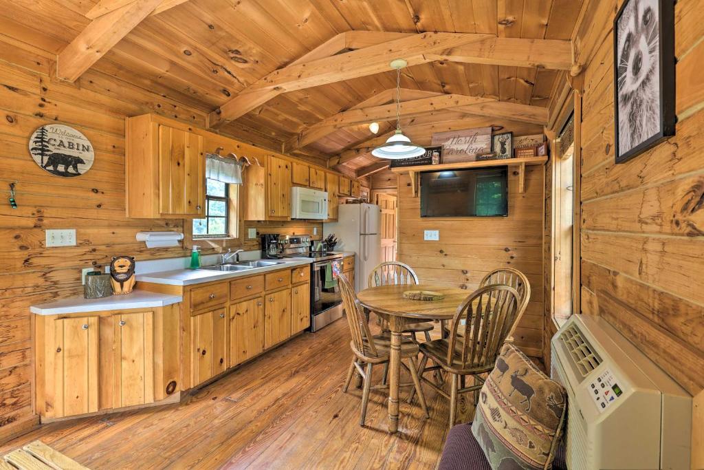 a kitchen with a table and chairs in a cabin at Quaint Log Cabin with Views Near West Jefferson in Warrensville