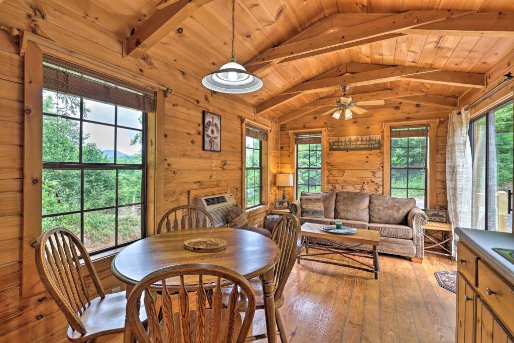 a dining room and living room with a table and chairs at Quaint Log Cabin with Views Near West Jefferson in Warrensville