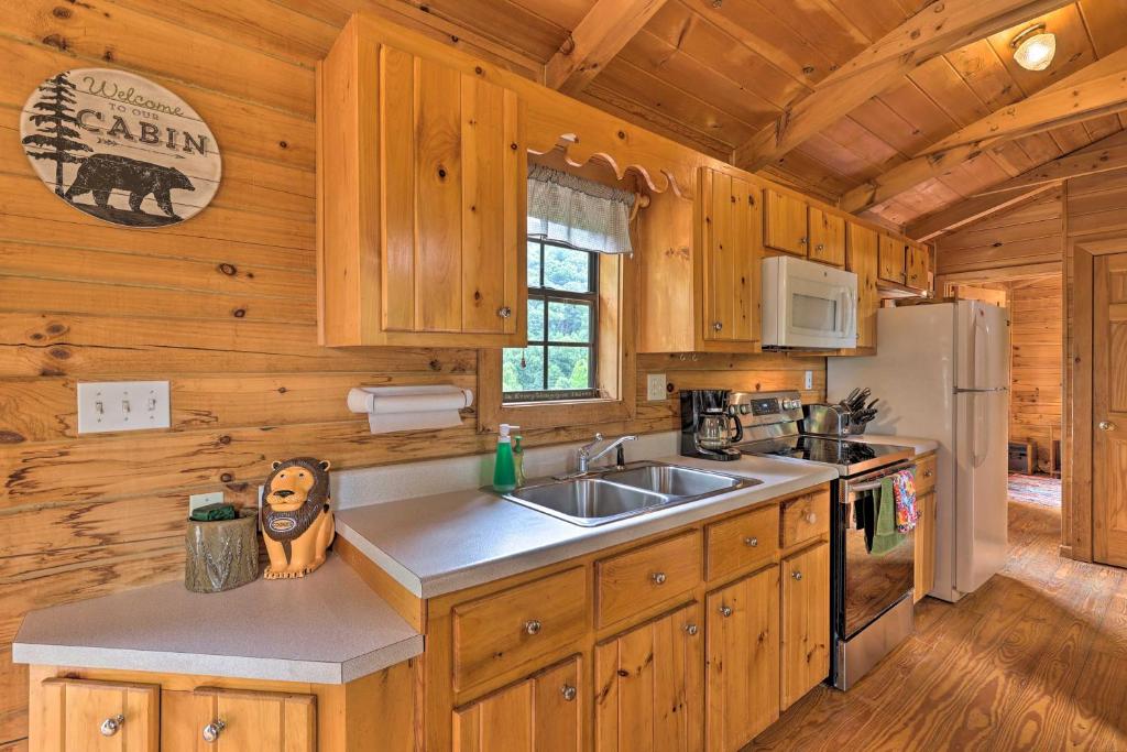 a kitchen with a sink and a refrigerator at Quaint Log Cabin with Views Near West Jefferson in Warrensville