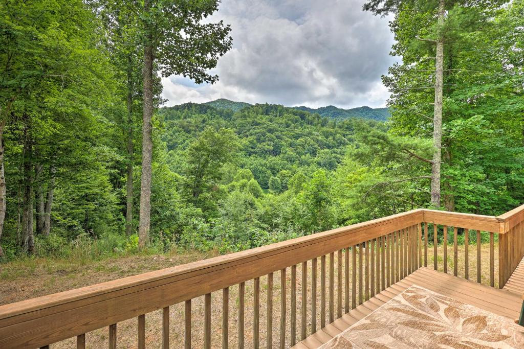 a wooden deck with a view of the woods at Quaint Log Cabin with Views Near West Jefferson in Warrensville