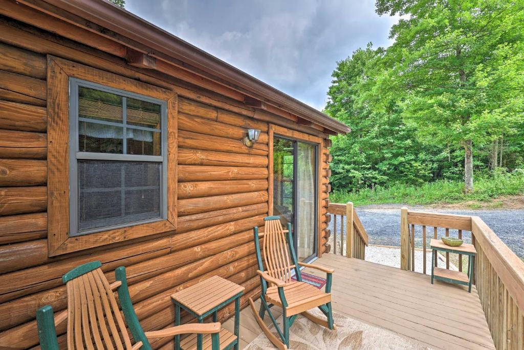 a cabin with two chairs and a table on a deck at Quaint Log Cabin with Views Near West Jefferson in Warrensville