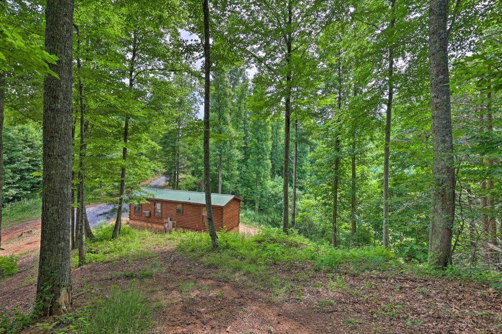 a log cabin in the middle of a forest at Quaint Log Cabin with Views Near West Jefferson in Warrensville
