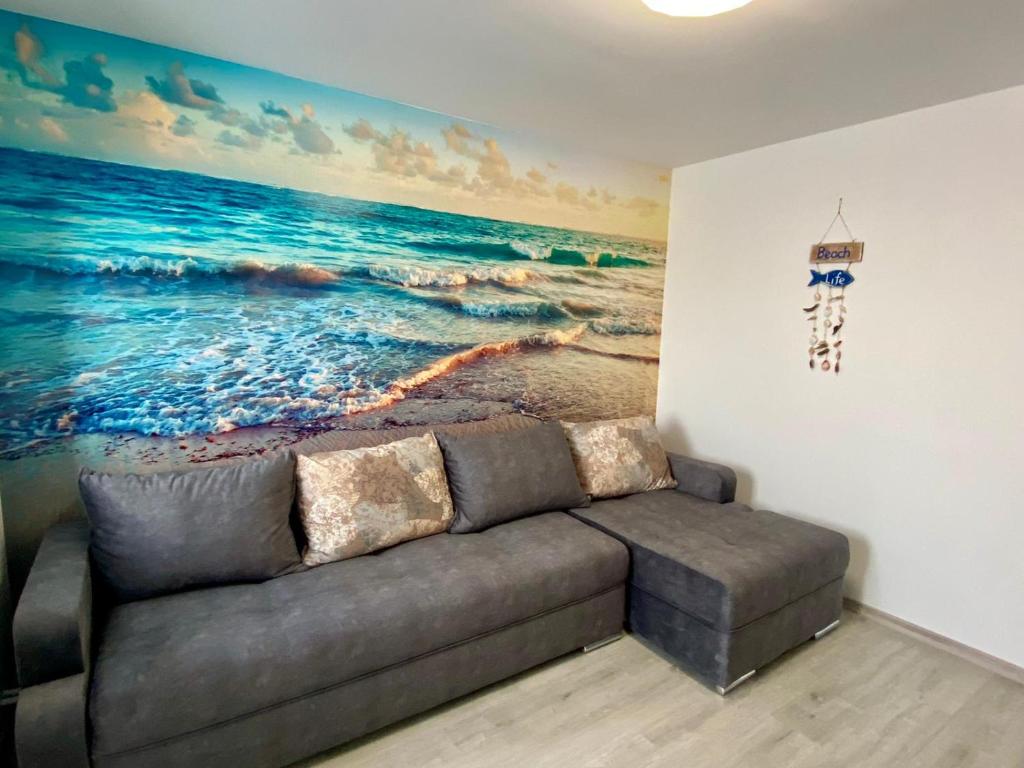 un divano in soggiorno con un dipinto sul muro di Apartament Livia a Jurilovca