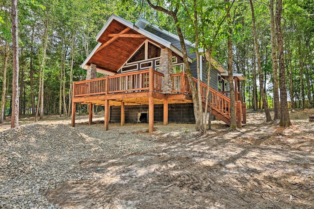 a large wooden house in the middle of a forest at Broken Bow Couples Retreat with Fire Pit and BBQ! in Broken Bow