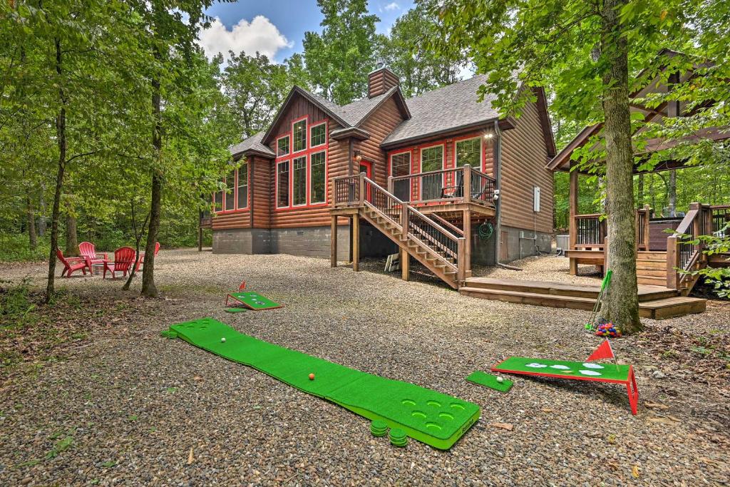 a log house with a green slide in front of it at Luxury Cabin with Hot Tub about 3 Miles to Hochatown! in Broken Bow