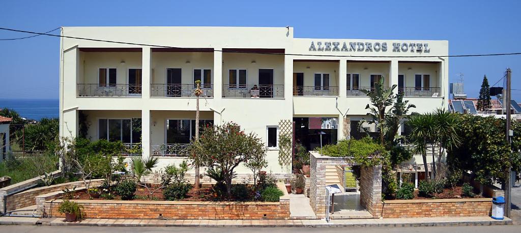 een groot wit gebouw met een bord erop bij Alexandros Hotel in Sissi