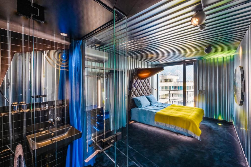 uma casa de banho com uma cama e uma cabina de duche em vidro em Telegraph Loft em Olomouc