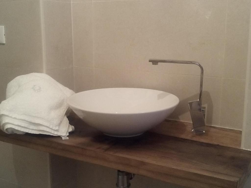 a white bowl on a wooden counter in a bathroom at Santa Caterina dello Ionio Boutique Apartments in Santa Caterina dello Ionio