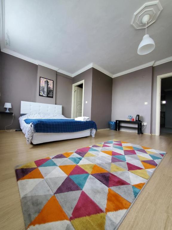 ein Schlafzimmer mit einem Bett und einem bunten Teppich in der Unterkunft Private Room Near İstanbul Airport in Arnavutköy