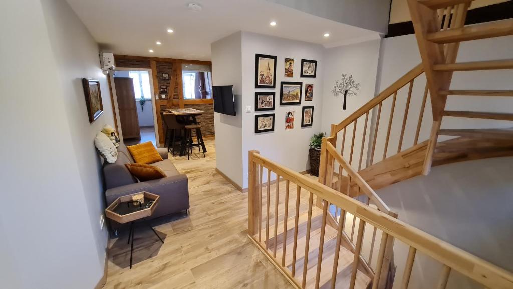 a living room with a staircase and a couch and a table at Appartement duplex climatisé avec terrasse "HANSI" in Colmar