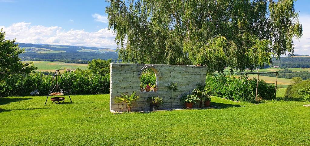 a stone wall with plants in a field at Ferienwohnung-Panoramablick-Küssaberg in Küssaberg