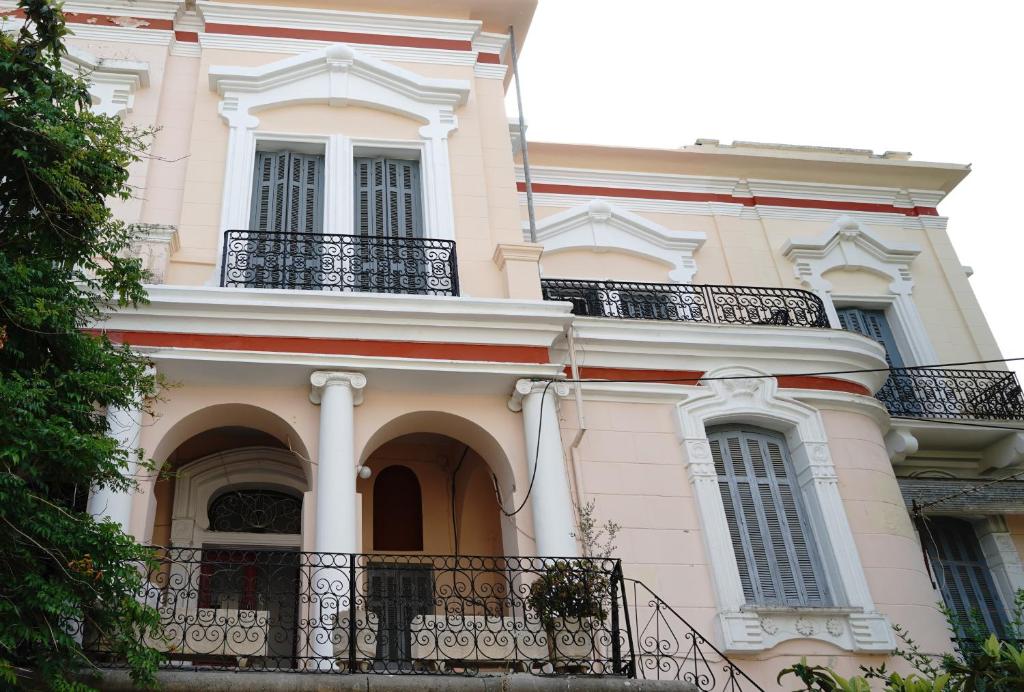 - un grand bâtiment blanc avec balcon et fenêtres dans l'établissement The Pitoulis Mansion, à Igoumenítsa