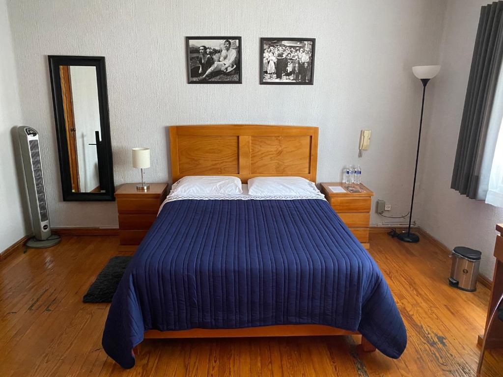 a bedroom with a large bed with a blue comforter at Cozy Private Room in Mexico City