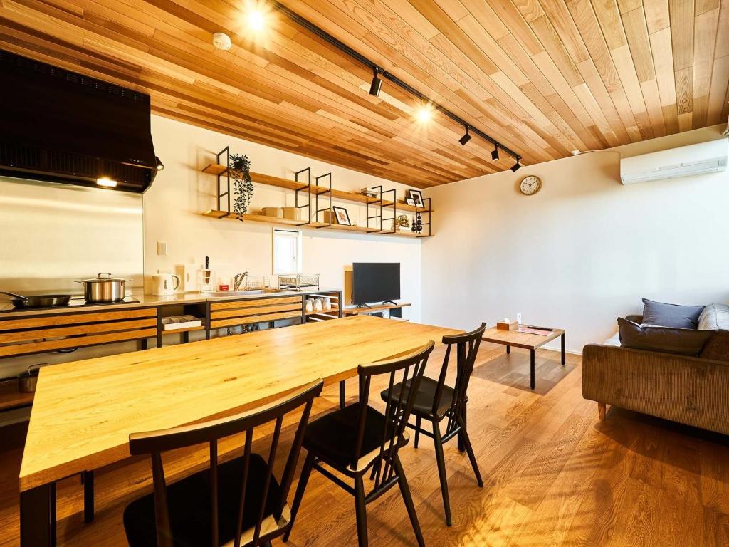 a dining room with a large wooden table and chairs at Rakuten STAY HOUSE x WILL STYLE Saga Imari 101 in Imari