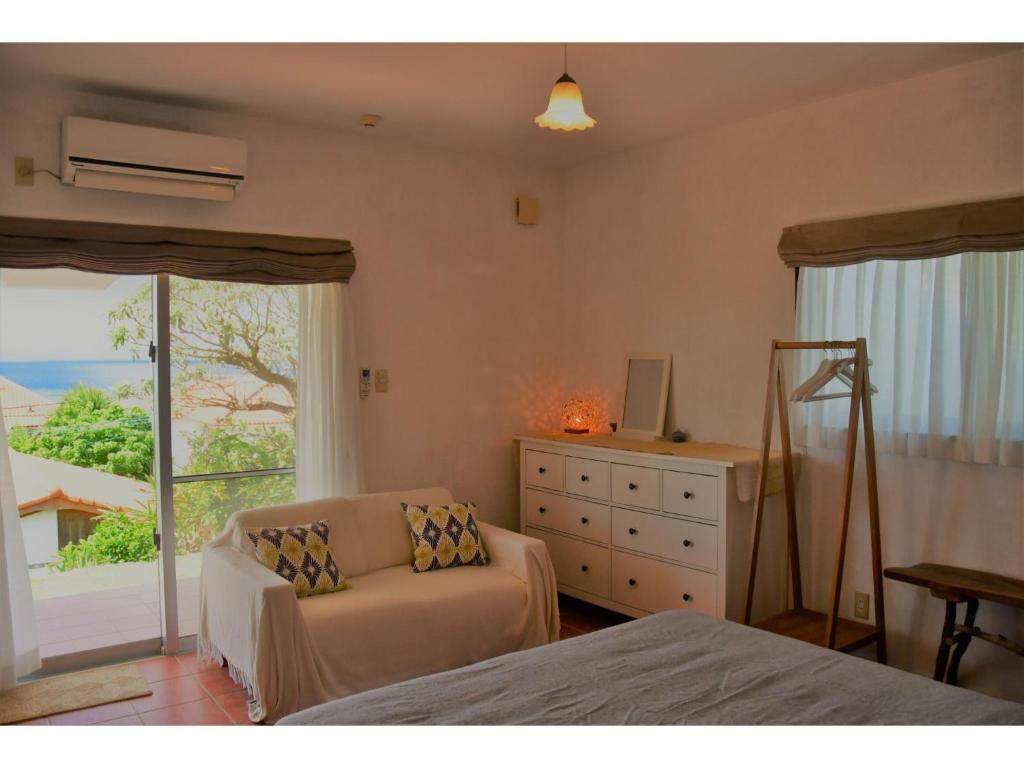 ein Schlafzimmer mit einem Bett und einem Stuhl und einem Fenster in der Unterkunft Terrace House yamabare - Vacation STAY 53924v in Fukai