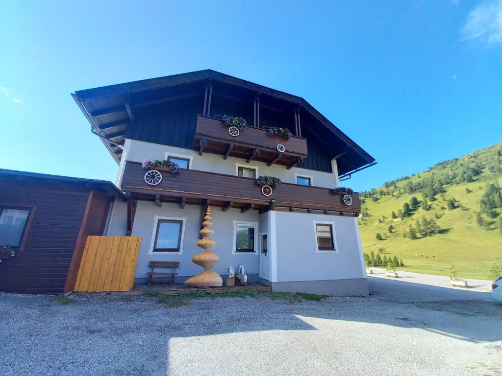 a house with a balcony on top of it at Ferienwohnungen Almsonne in Thomatal