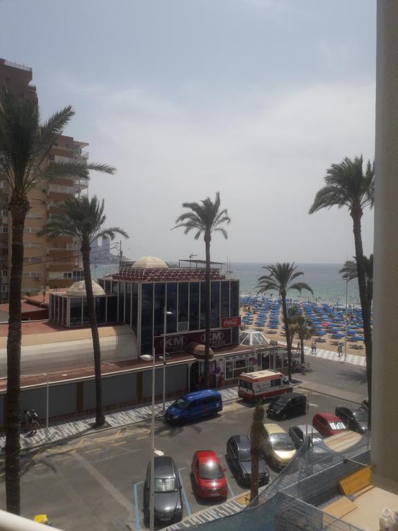 een uitzicht op een parkeerplaats met palmbomen en de oceaan bij REX CUATRO in Benidorm