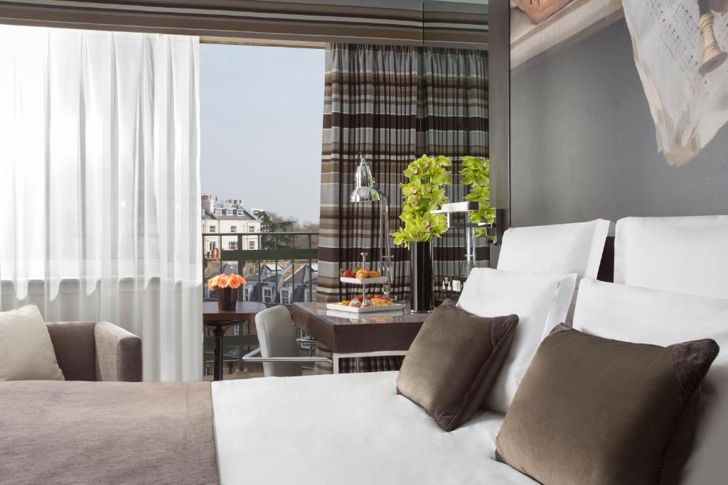 - une chambre avec un lit et une salle à manger dans l'établissement Jumeirah Lowndes London, à Londres