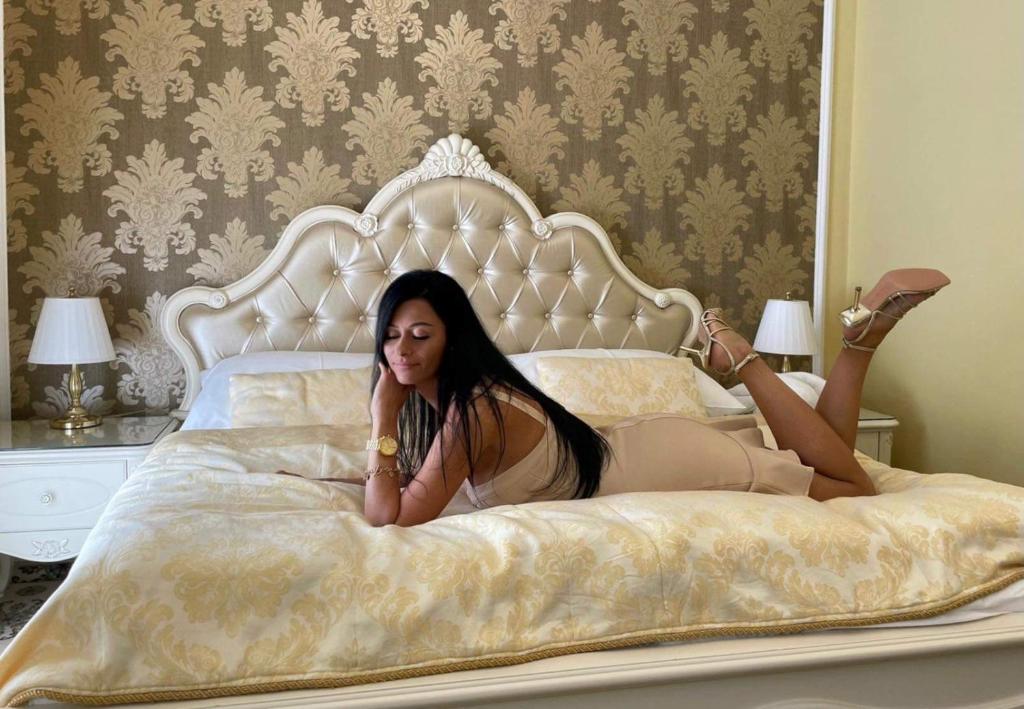 Una mujer acostada en una cama con las piernas levantadas en Hotel Saint Petersburg, en Karlovy Vary