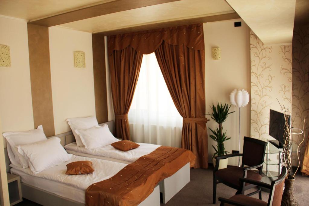 Un dormitorio con una cama grande y una ventana en Enigma Pension, en Târgu Jiu