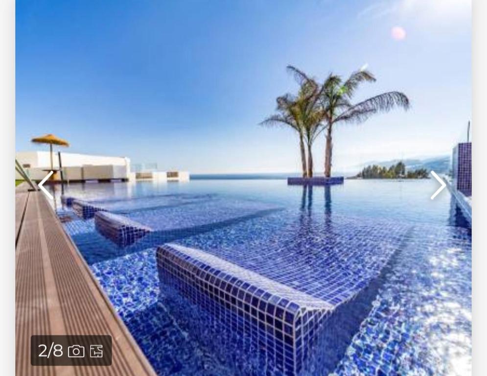 una gran piscina con vistas al océano en Piso de lujo en la playa de un pueblo de Granada con piscina infiniti, yacuzzi en la piscina, tumbonas privadas y mucho más, en Melicena