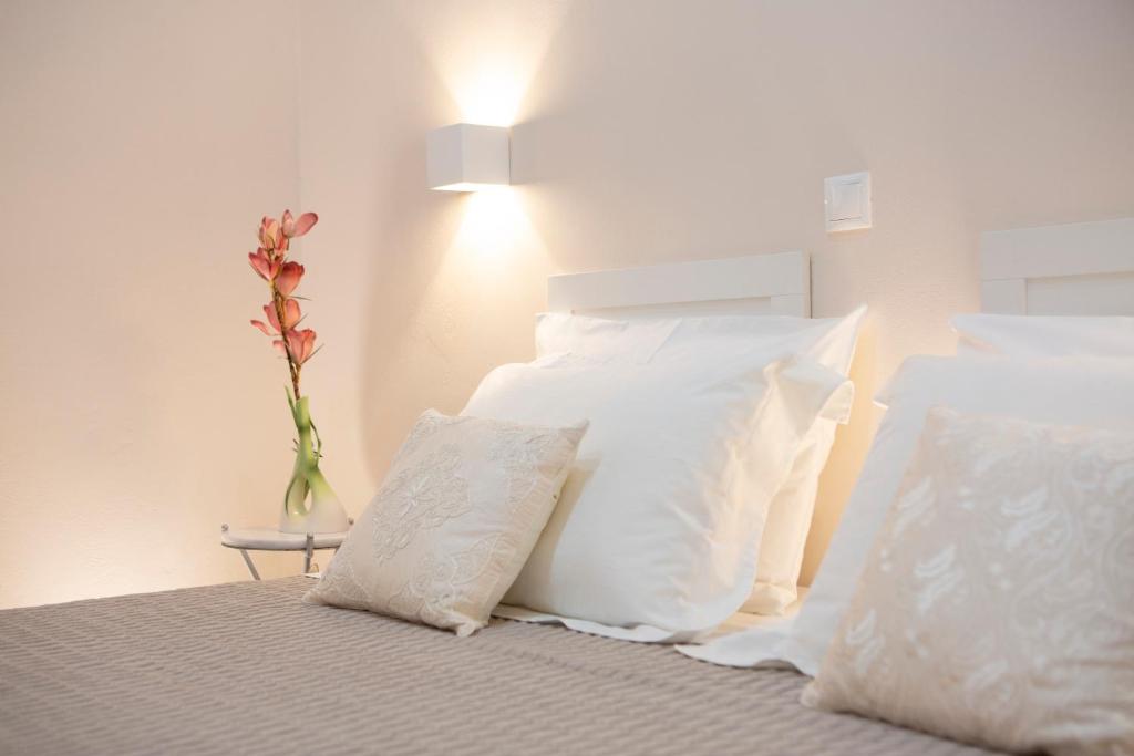 2 almohadas blancas en una cama con jarrón en Centrale Lefkada old town, en Lefkada