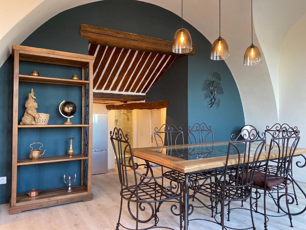 une salle à manger avec une table et des chaises en verre dans l'établissement Grand Appartement Centre historique Grasse, à Grasse