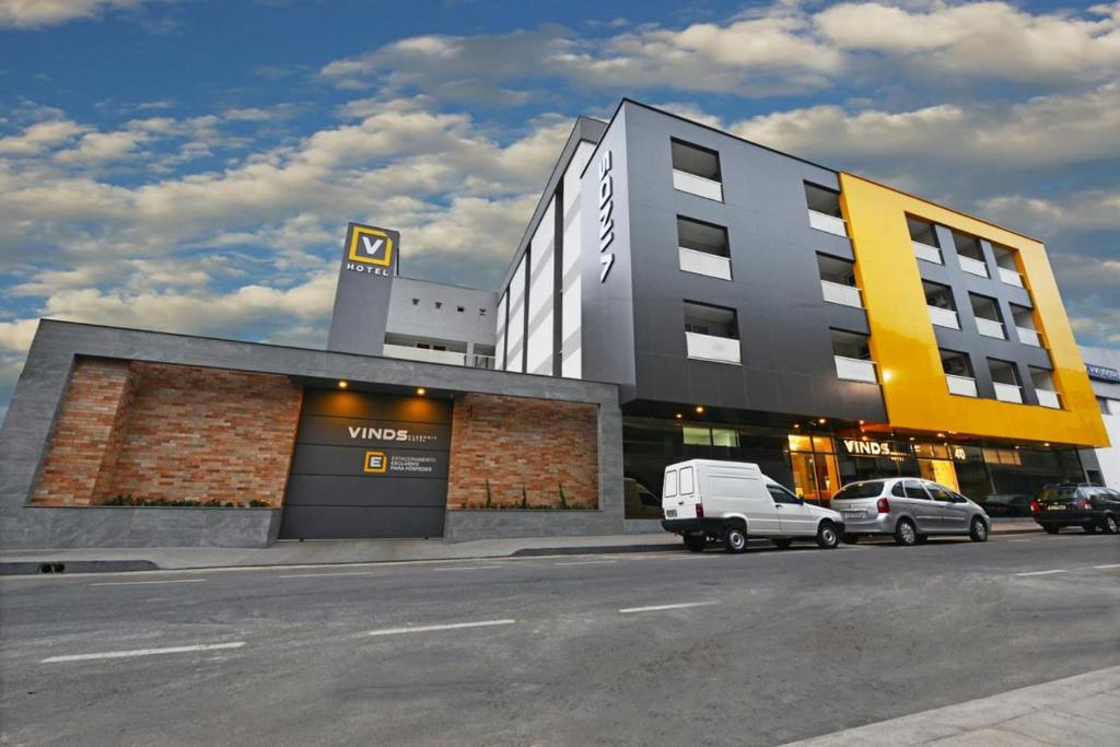 Una camioneta blanca estacionada frente a un edificio en Vinds Economic Hotel, en Ipatinga