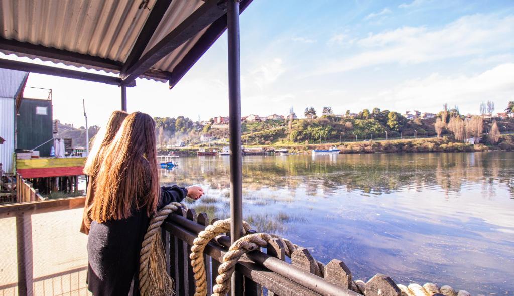 een vrouw op een boot die naar het water kijkt bij Palafito Hospedaje Vista Bordemar in Castro