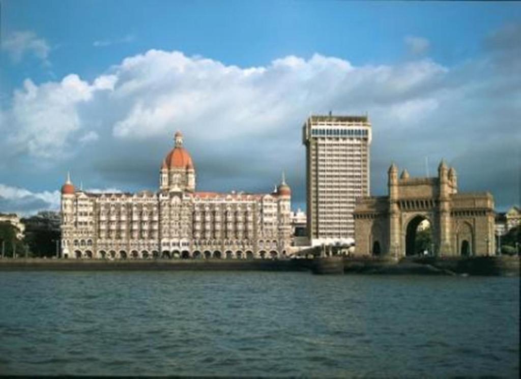 un grande edificio accanto a un corpo idrico di The Taj Mahal Tower, Mumbai a Mumbai