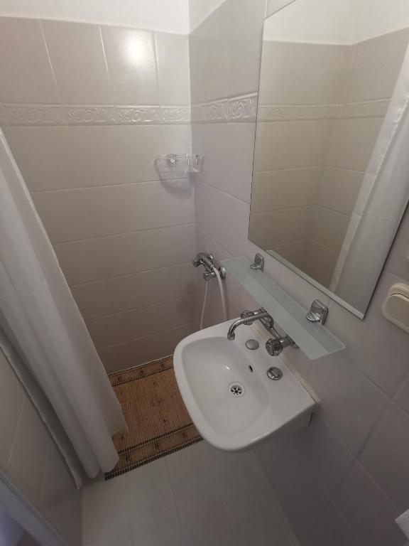 biała łazienka z umywalką i lustrem w obiekcie Willa Daniela w Rewalu
