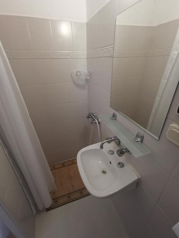 biała łazienka z umywalką i lustrem w obiekcie Willa Daniela w Rewalu