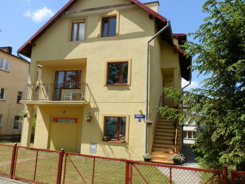 żółty dom z płotem przed nim w obiekcie Willa Daniela w Rewalu