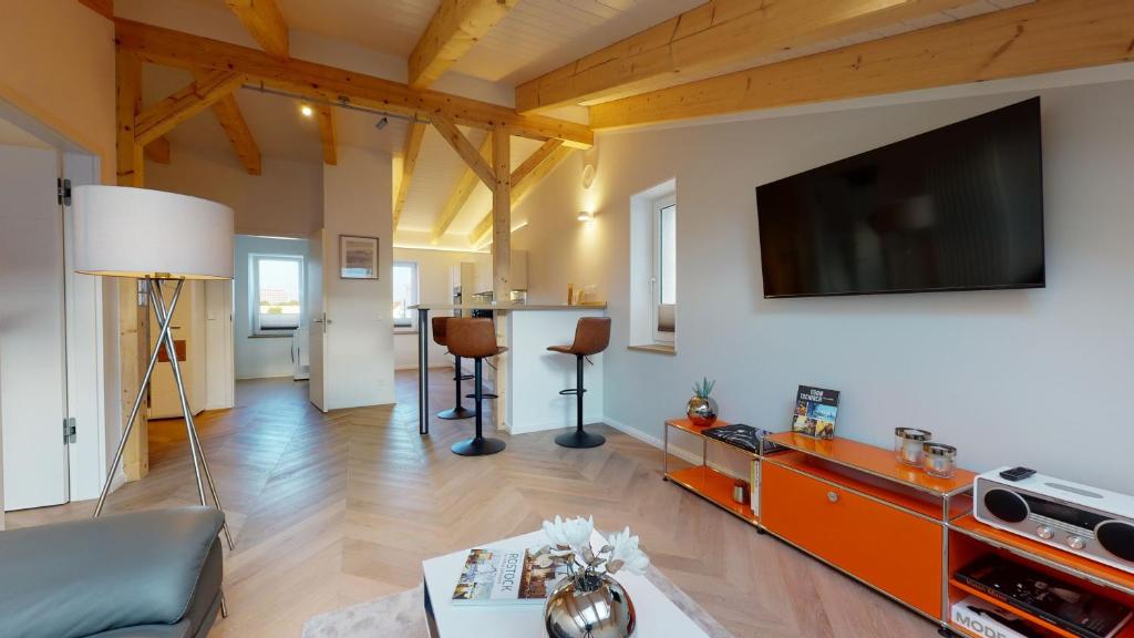 a living room with a flat screen tv on a wall at Lieblingsapartment No.08 mit Blick auf den Rostocker Stadthafen in Rostock