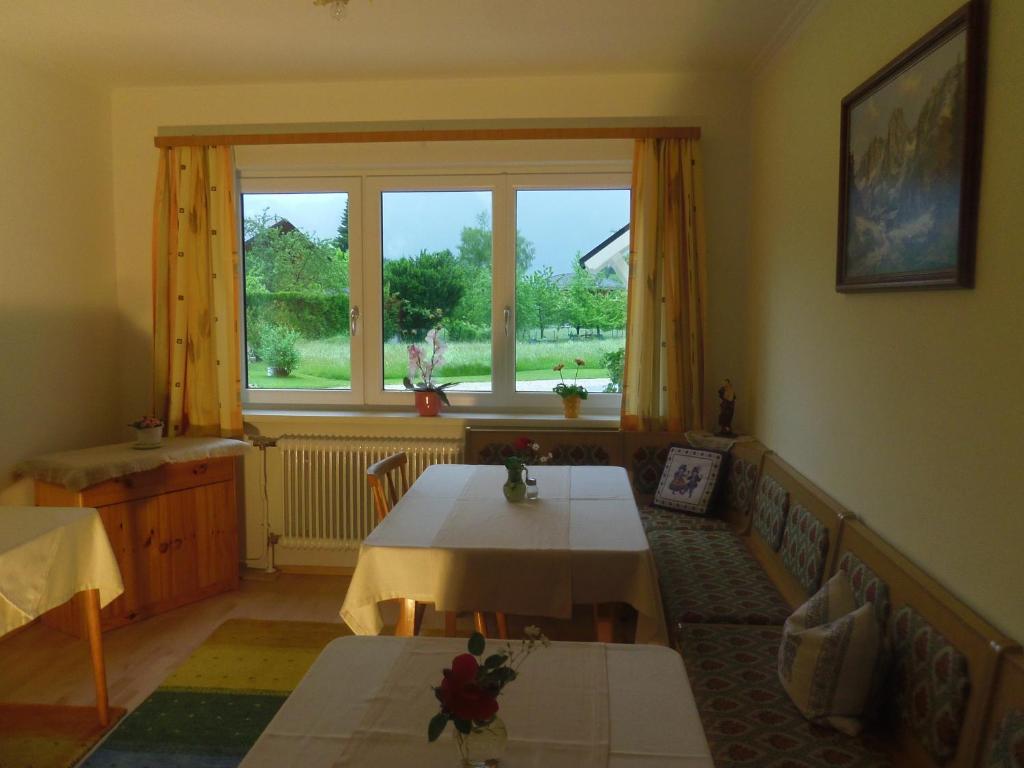 un soggiorno con un tavolo e una grande finestra di Haus Amalia a Strobl