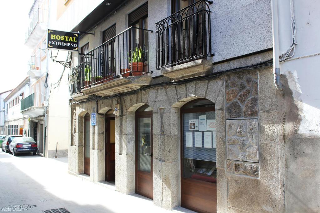 eine Fassade eines Gebäudes mit Fenstern und einem Balkon in der Unterkunft Hostal Extremeño in Béjar