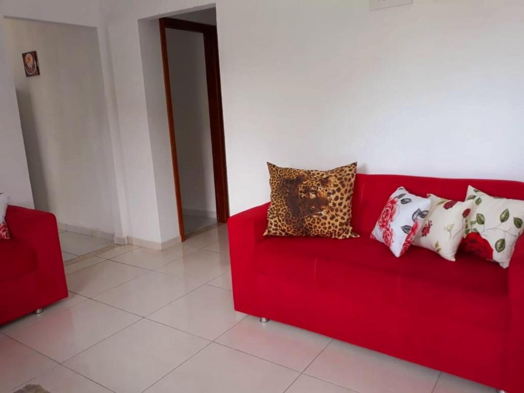 Un sofá rojo con un montón de almohadas. en Casa Azul Gamboa, en Gamboa