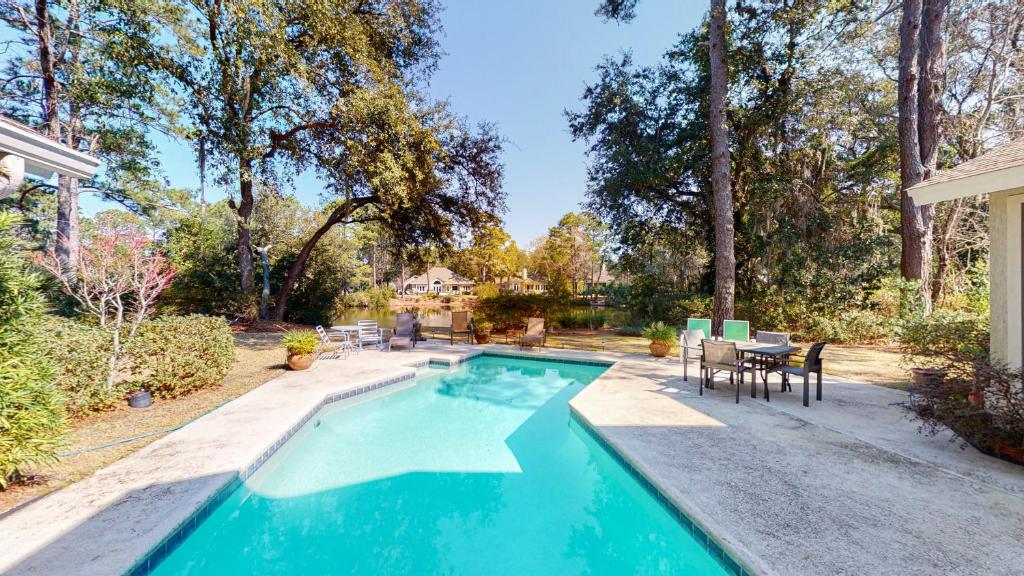 a swimming pool in a yard with a table and chairs at 2 Off Shore in Hilton Head Island