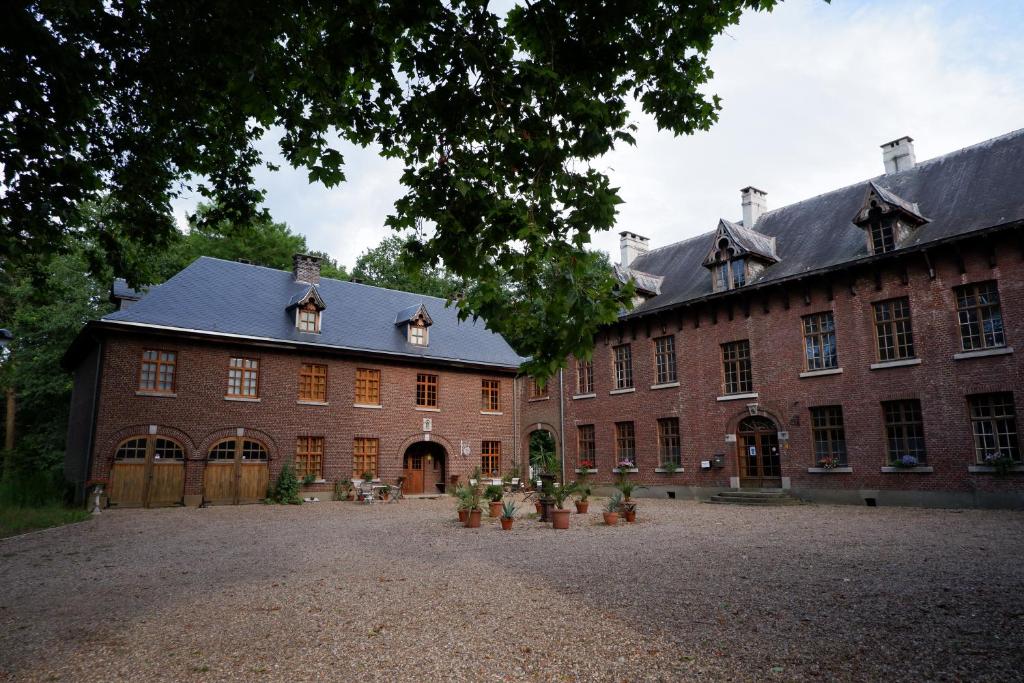 un grand bâtiment en briques rouges avec une grande cour dans l'établissement Het Domherenhuis, à Heusden-Zolder