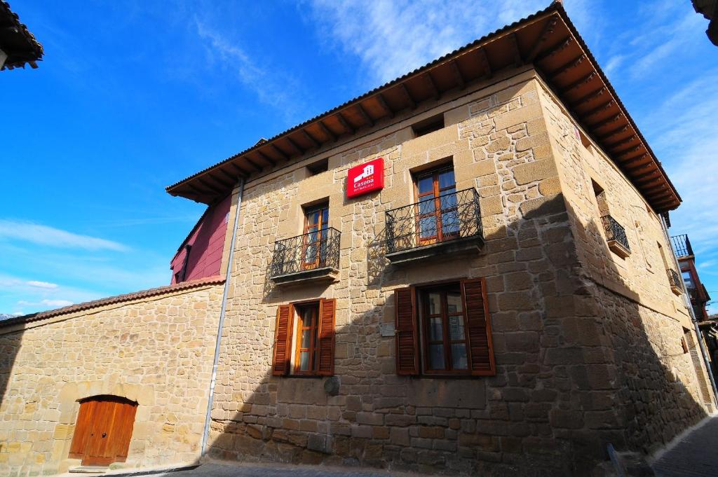 a building with a red sign on the side of it at Casona del Boticario in San Vicente de la Sonsierra