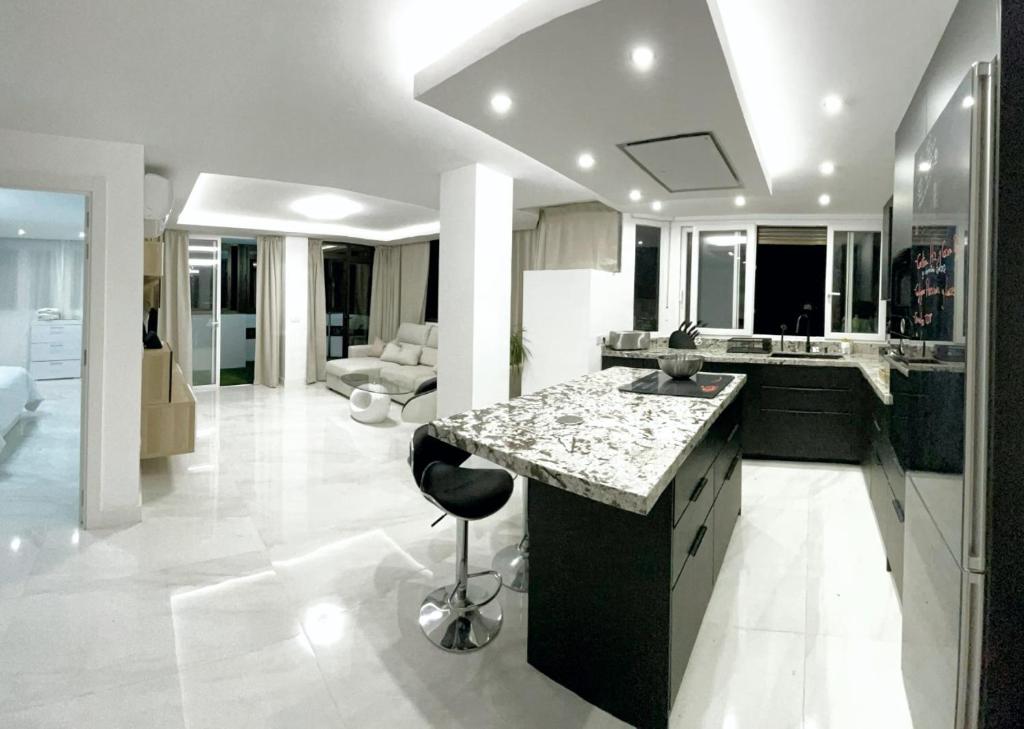 a kitchen with a counter and a stool in a room at Apartamento IMPERIO 2 - Marbella centro in Marbella