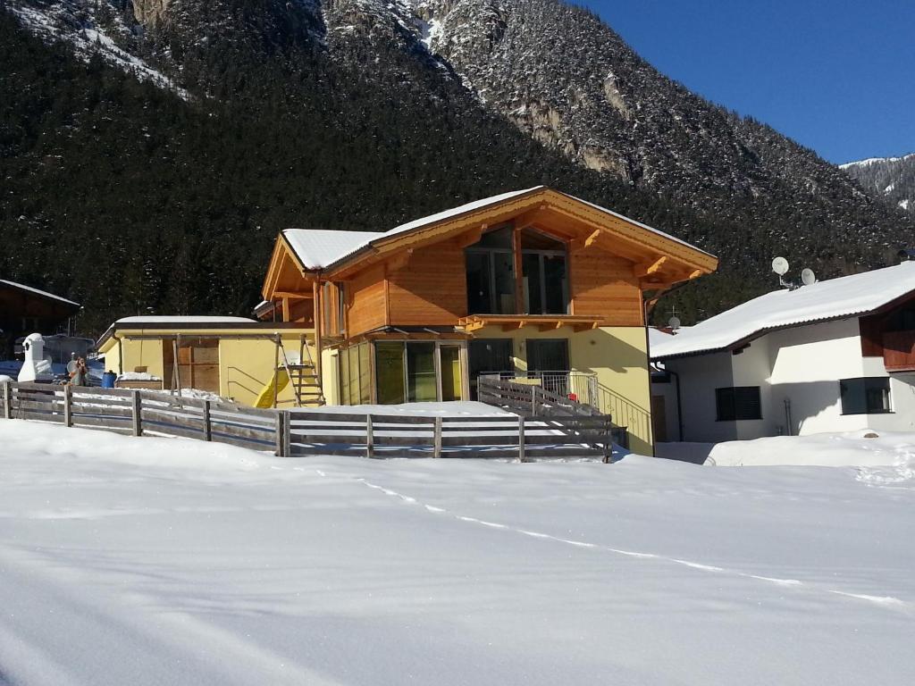 una casa en la nieve frente a una montaña en Ferienwohnung Familie Tost, en Trins